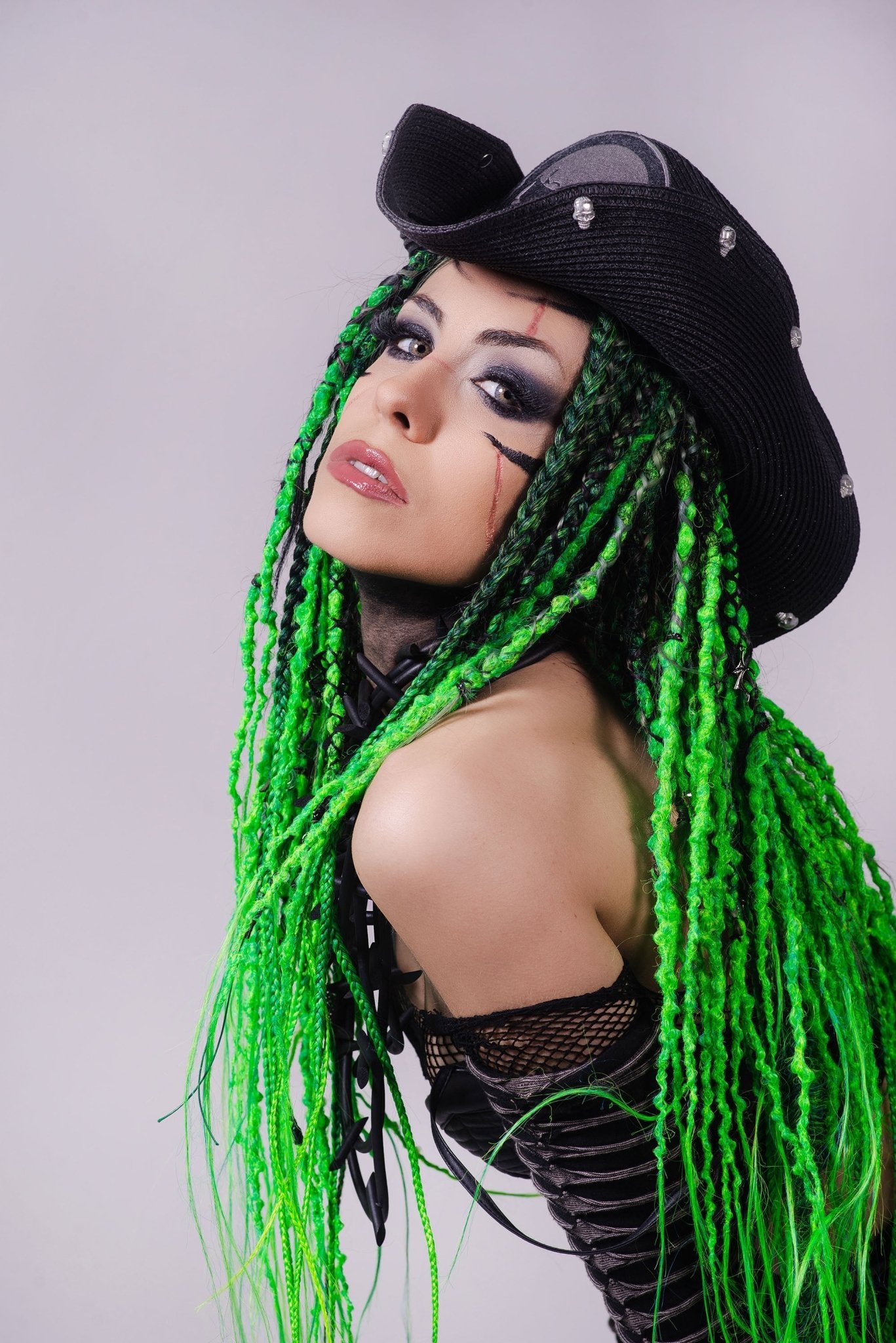 Girl with fluo green dreads in a black hat