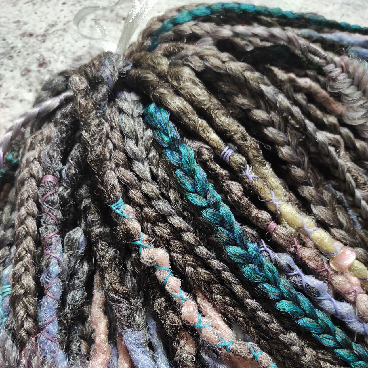 Pastel synthetic dreads with turquoise and brown-to-pink ombre extensions, including purple accents.