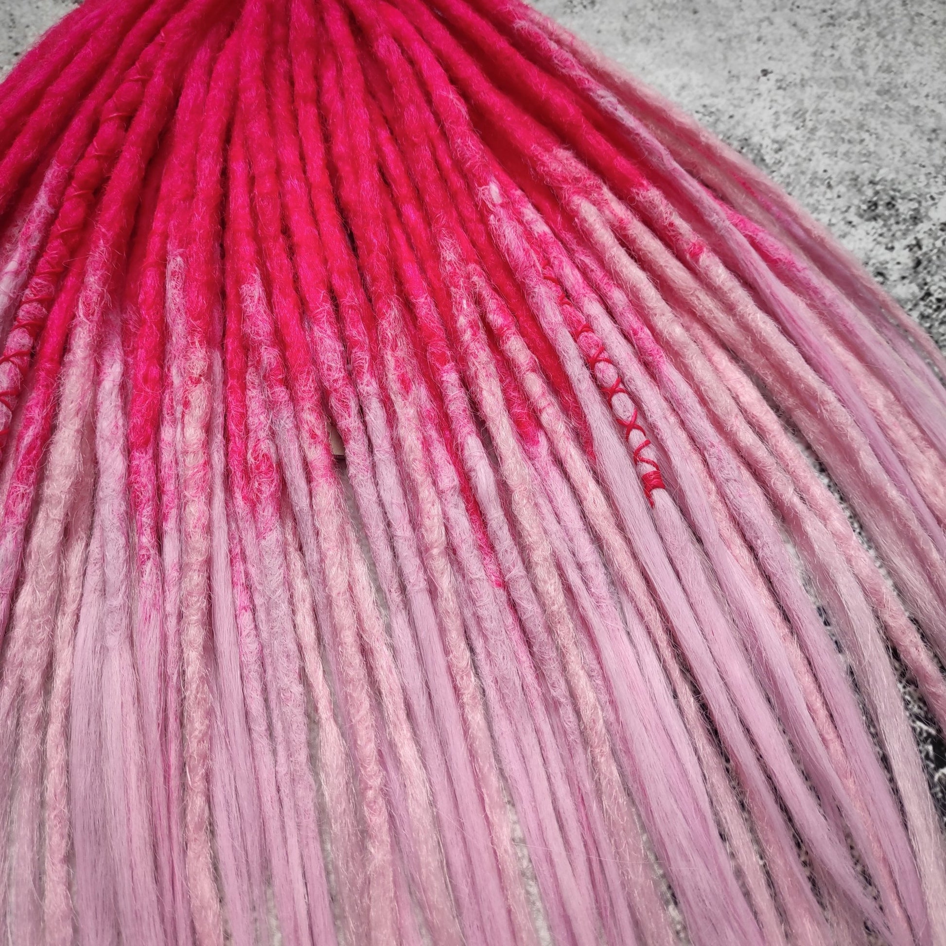 Synthetic double-ended dreads with a pink ombre effect
