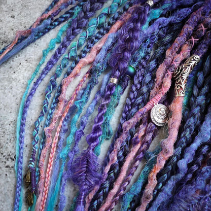 Purple synthetic dreads featuring brown-to-pink, turquoise, and blue ombre extensions, along with braids