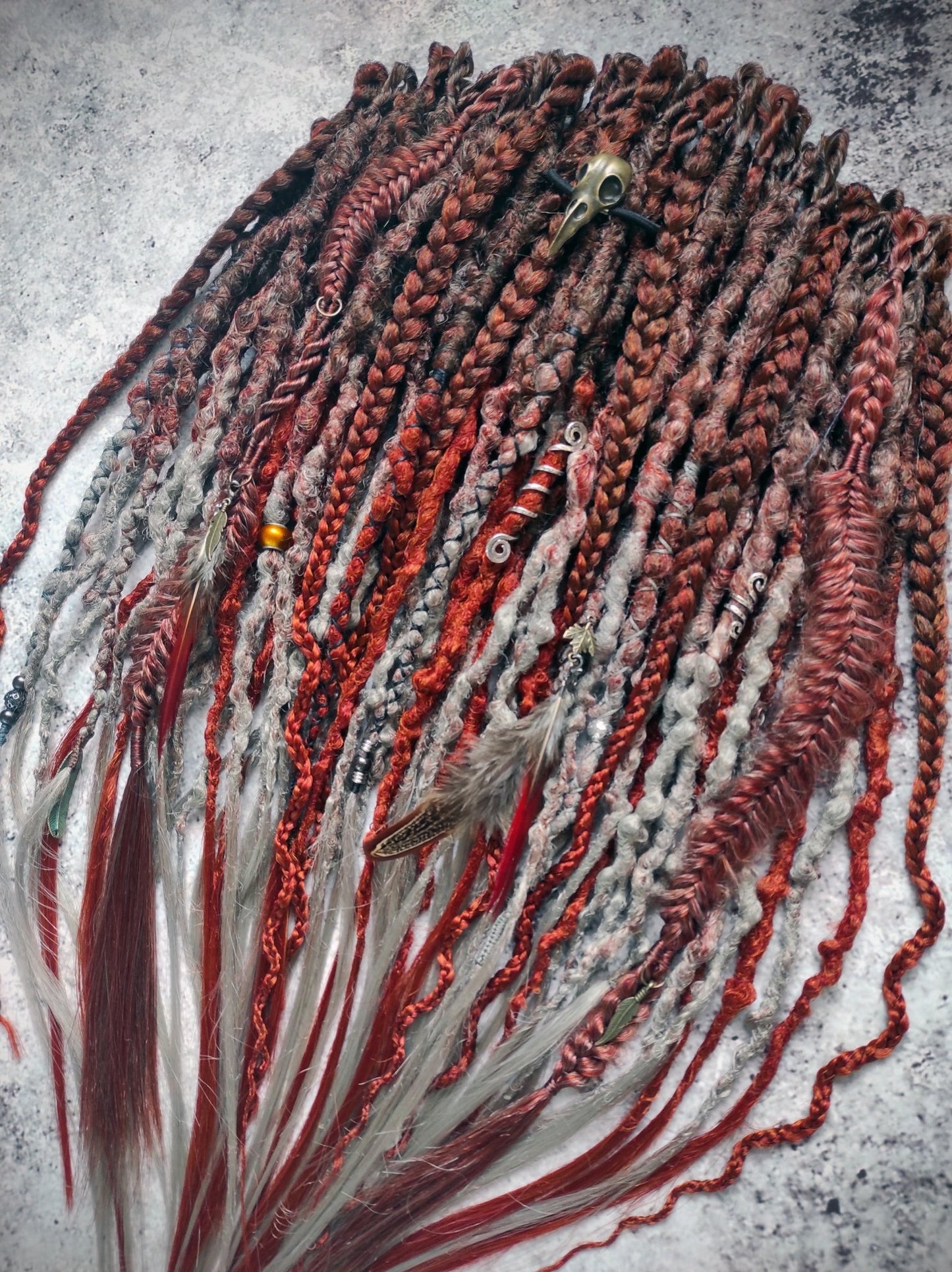 Synthetic dreads featuring a red auburn ombre transitioning to gray, complemented by braids